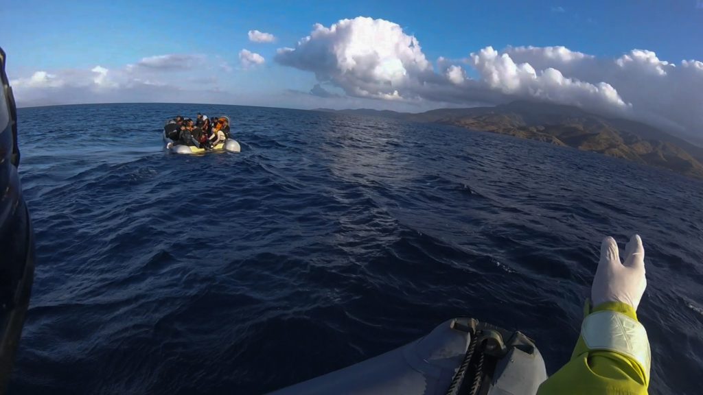 Refugee Rescue's crew on Mo Chara attempt to guide a dinghy to safe land.