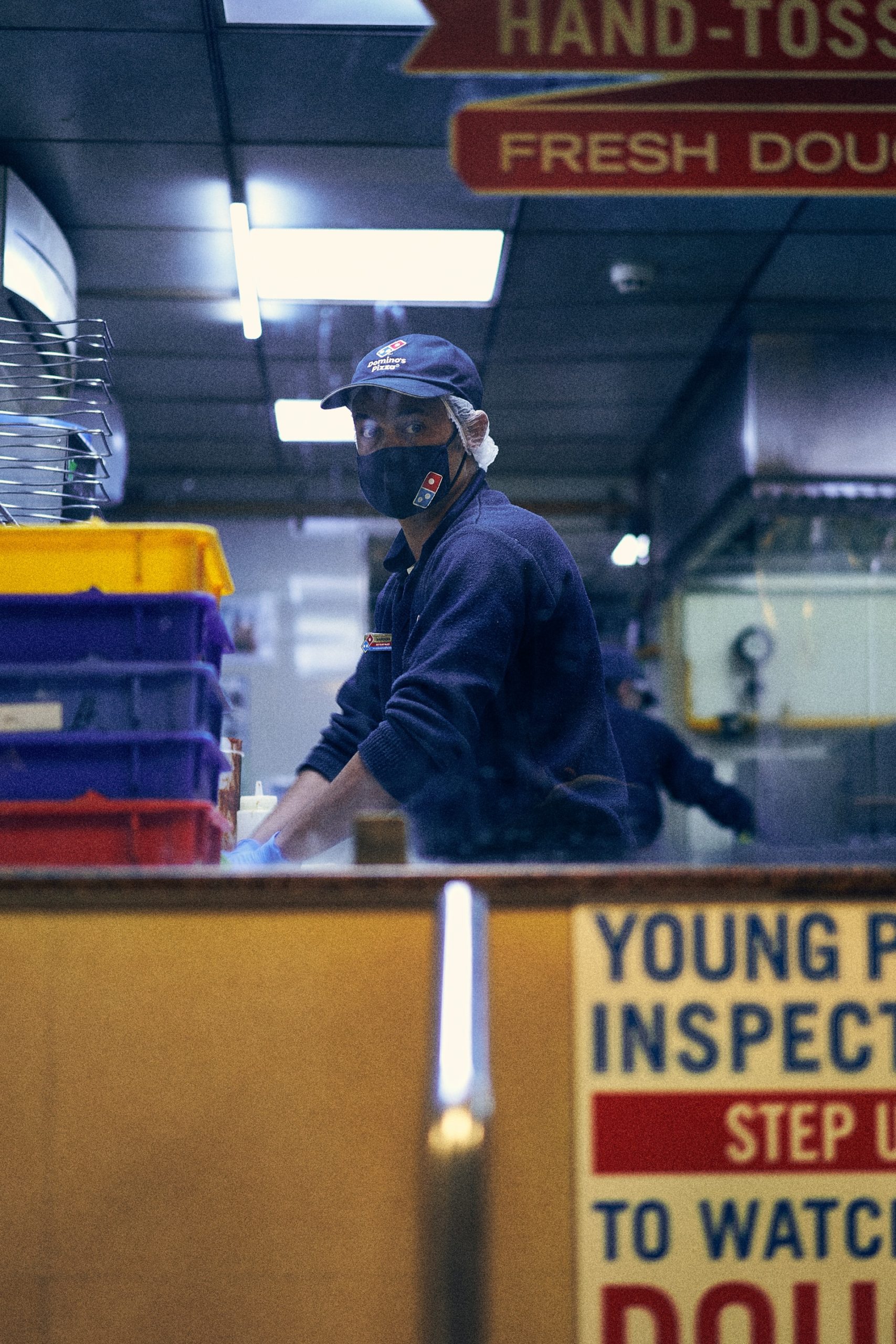 A man wearing mask working at Domino's