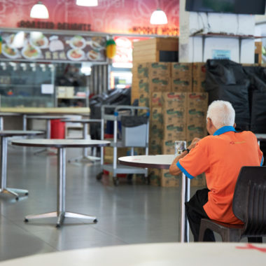 Janitor eating alone in Singapore food court