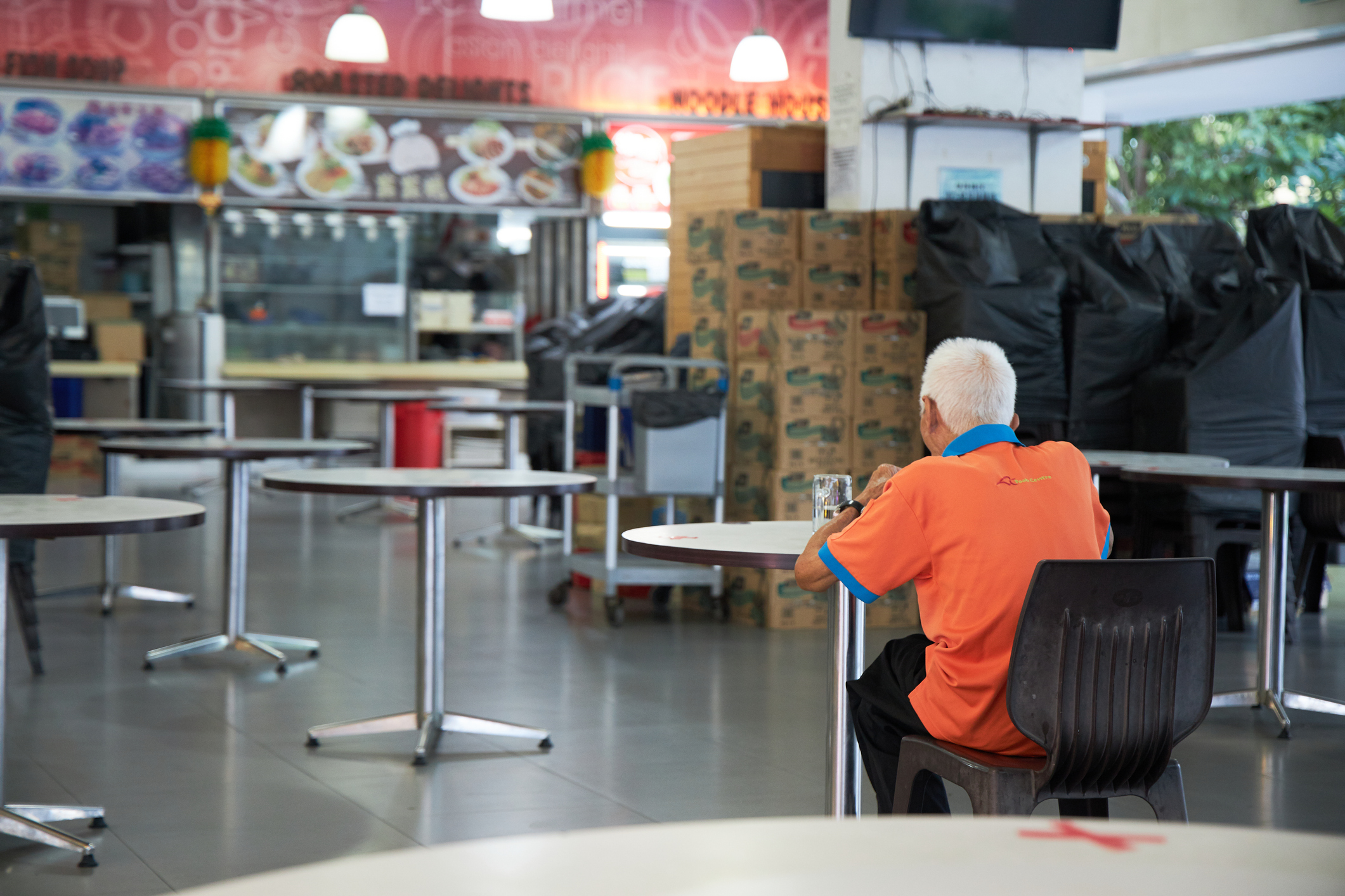 Janitor eating alone in Singapore food court