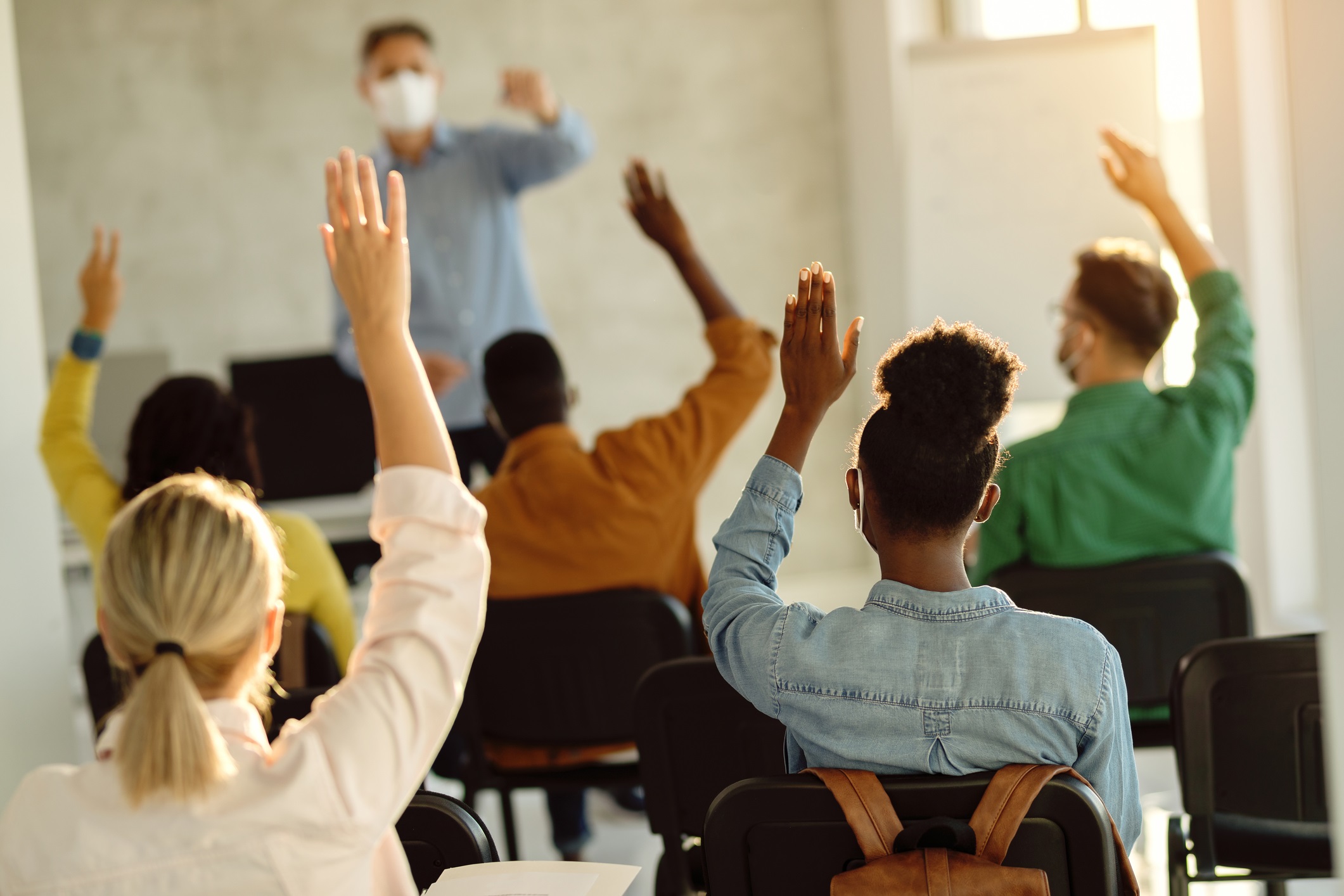 Students raise their hands to ask questions