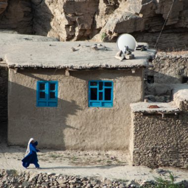 Woman walking past buildings, Badakhshan, Afghanistan