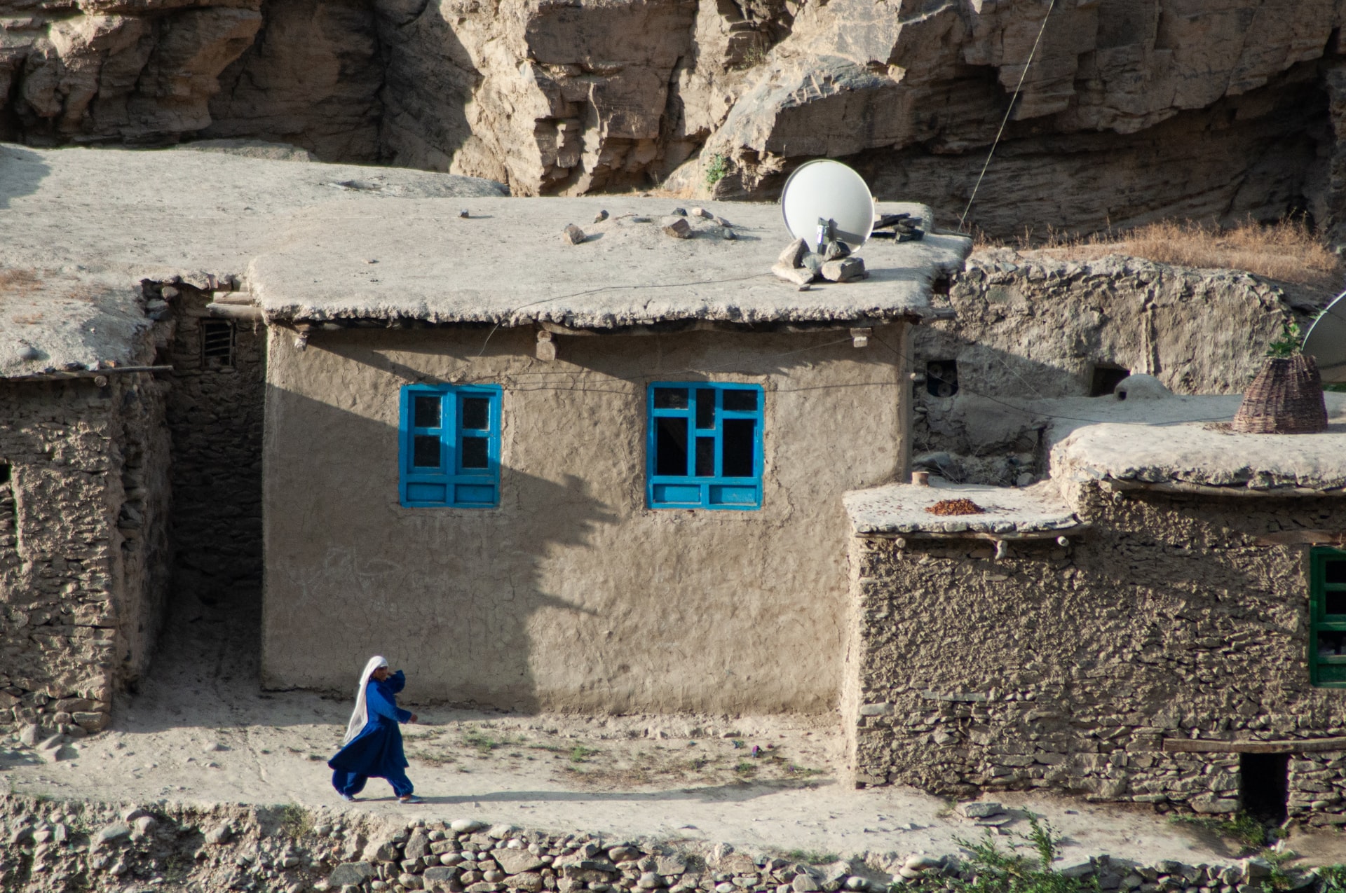 Woman walking past buildings, Badakhshan, Afghanistan